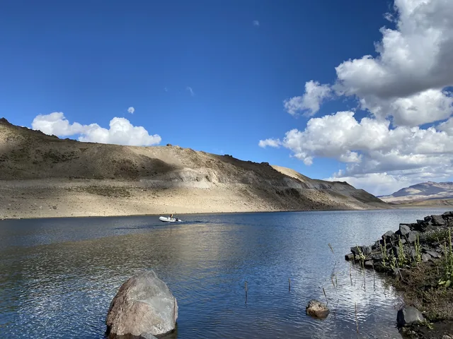 Levantamiento en un cuerpo de agua rodeado por formaciones geológicas